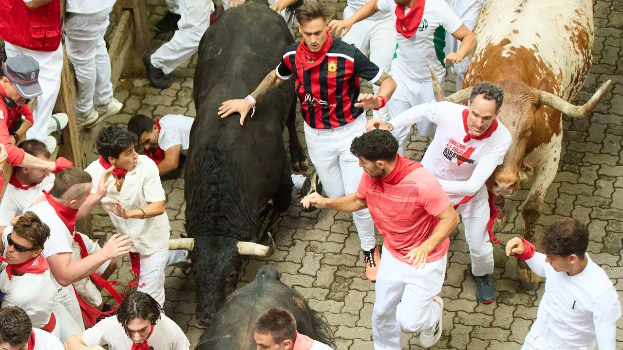 Primer encierro de San Fermín 2025 con toros de Fuente Ymbro en el tramo de Telefónica y el callejón de entrada a la plaza. IÑIGO ALZUGARAY