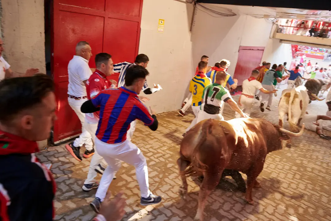 Tercer encierro de San Fermín 2025 con toros de Álvaro Nuñez en la bajada del callejón en Telefónica. IRANZU LARRASOAÑA