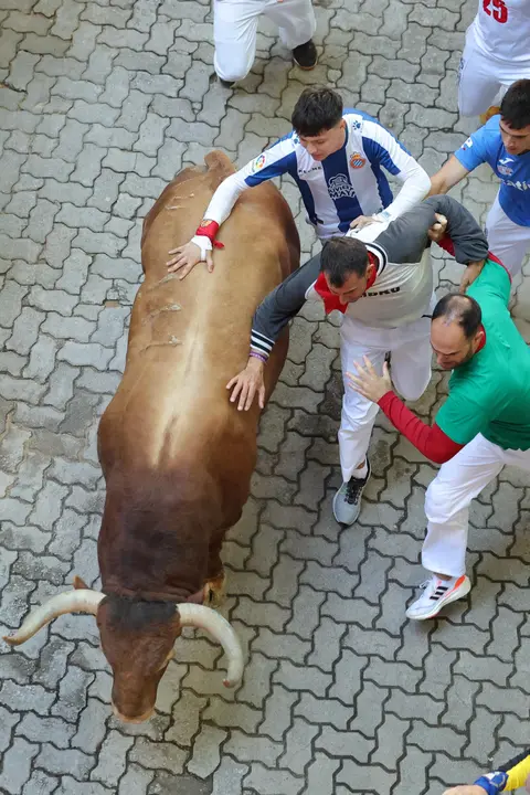 Cuarto encierro de San Fermín 2025 el día 10 de julio con toros de Victoriano del Río en la bajada al callejón. EFE - J.P. URDIROZ (1)