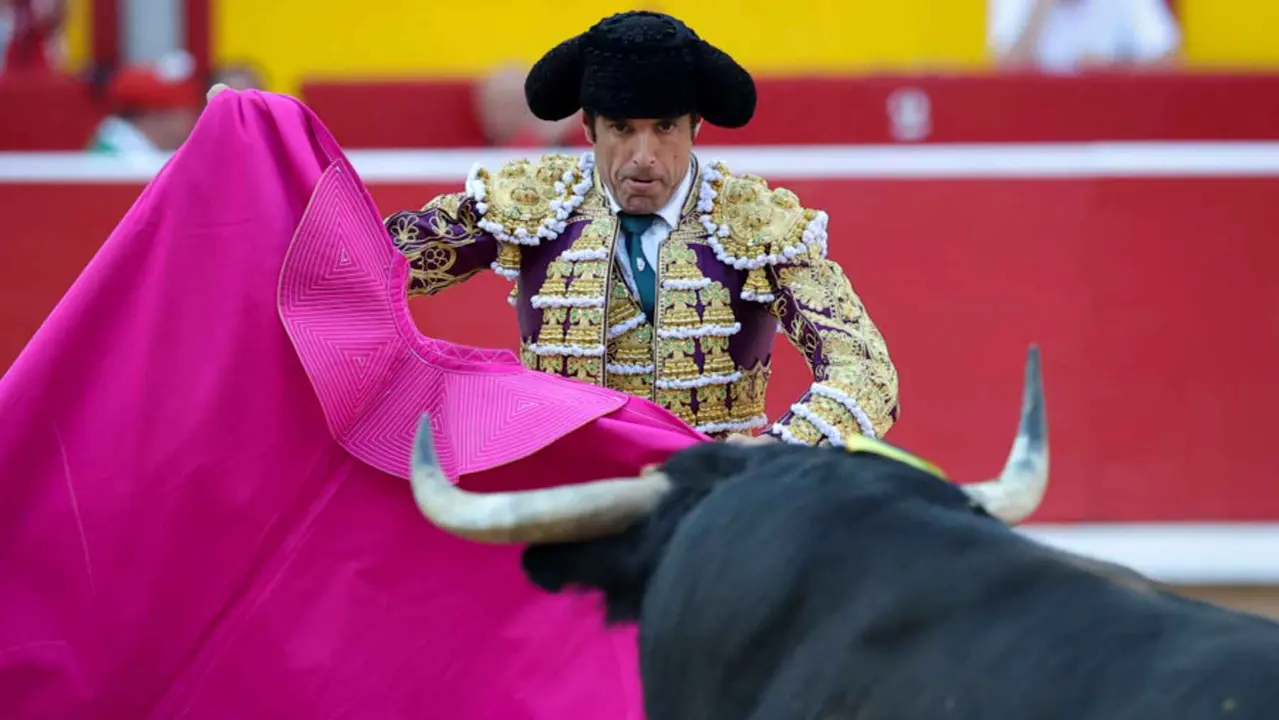 El torero Emilio de Justo recibe con el capote a su segundo toro de la tarde en la sexta de abono de la Feria de Toro de los Sanfermines 2025 con toros de la ganadería madrileña de Victoriano del Río Cortés y en la que comparte cartel con los diestros Sebastián Castella y Borja Jiménez. EFE/J.P. Urdíroz