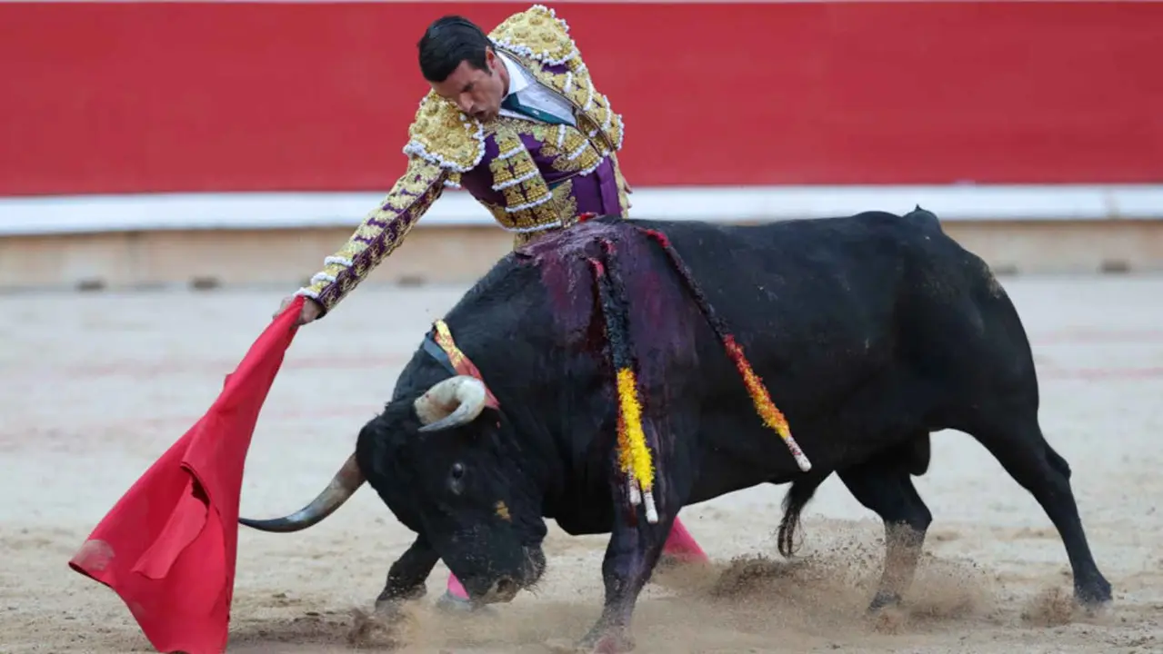 El torero Emilio de Justo recibe con el capote a su segundo toro de la tarde en la sexta de abono de la Feria de Toro de los Sanfermines 2025 con toros de la ganadería madrileña de Victoriano del Río Cortés y en la que comparte cartel con los diestros Sebastián Castella y Borja Jiménez. EFE/J.P. Urdíroz