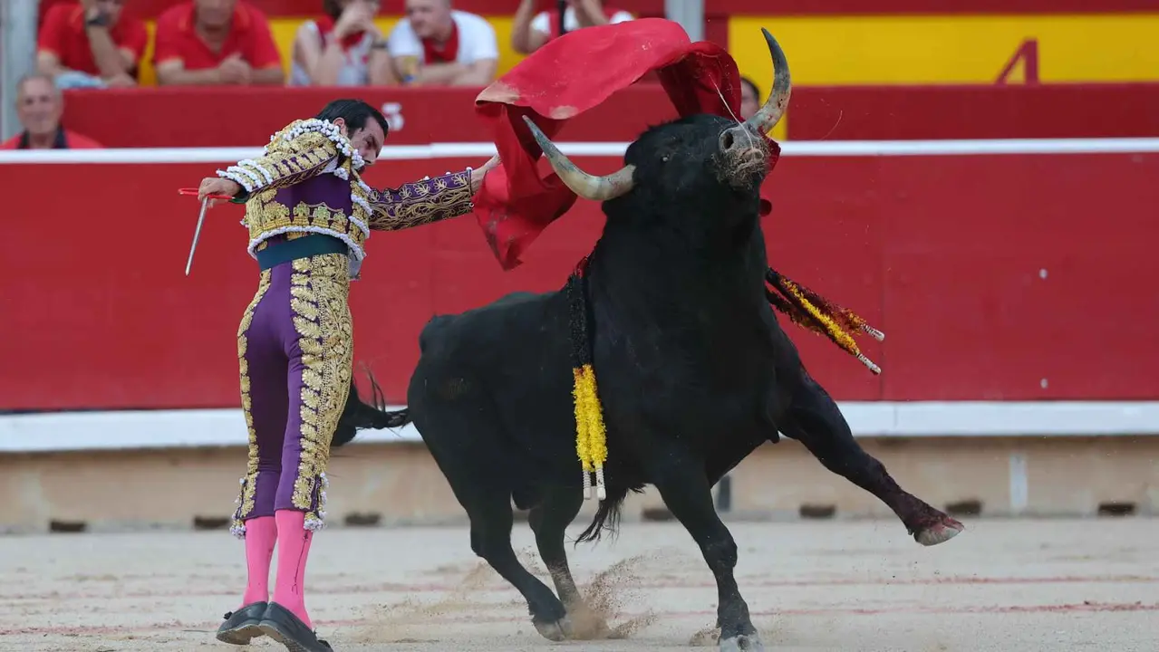 El torero Emilio de Justo recibe con el capote a su segundo toro de la tarde en la sexta de abono de la Feria de Toro de los Sanfermines 2025 con toros de la ganadería madrileña de Victoriano del Río Cortés y en la que comparte cartel con los diestros Sebastián Castella y Borja Jiménez. EFE/J.P. Urdíroz