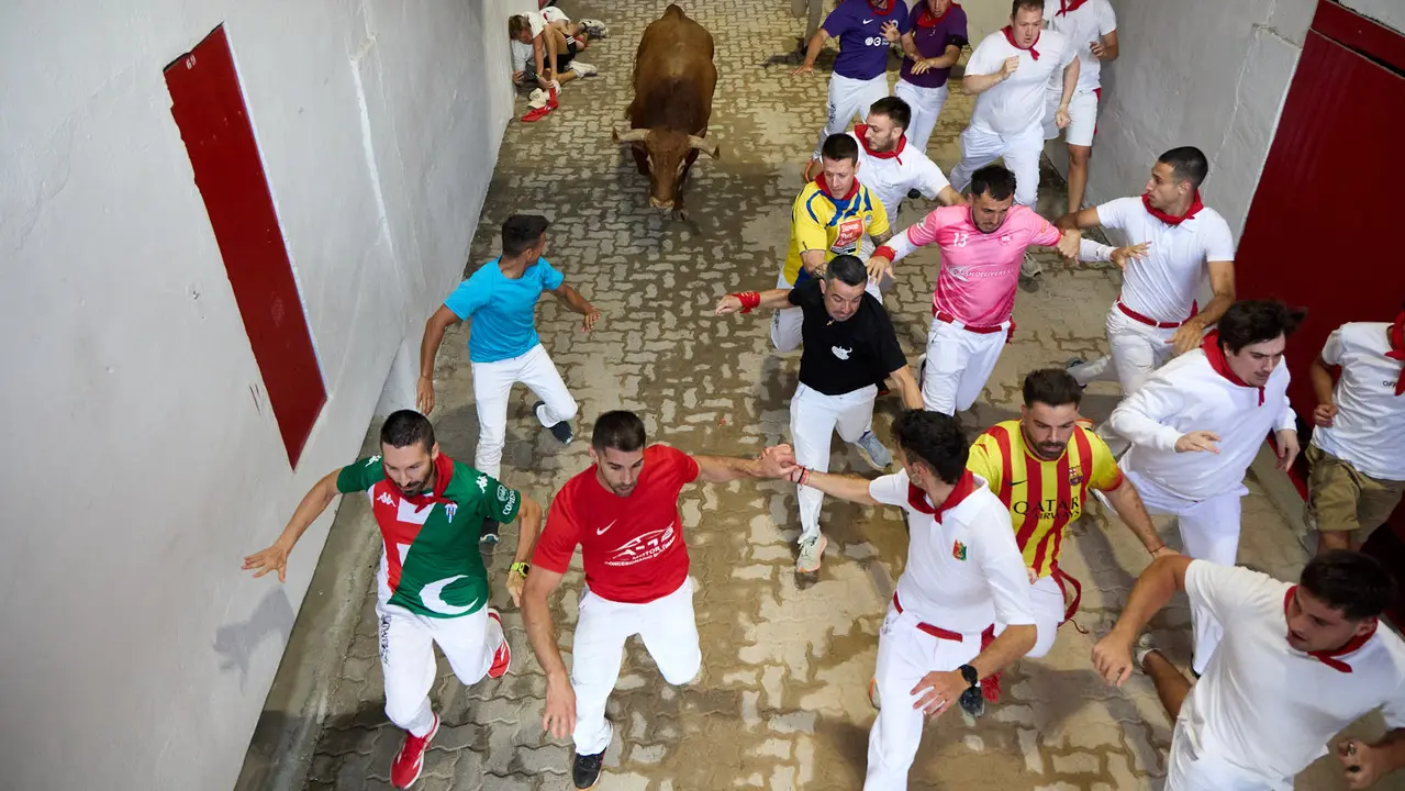 Quinto encierro de San Fermín 2025 con toros de la ganadería de Jandilla en el tramo del callejón y la entrada a la Plaza de Toros. IÑIGO ALZUGARAY