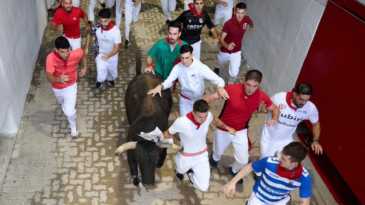 Quinto encierro de San Fermín 2025 con toros de la ganadería de Jandilla en el tramo del callejón y la entrada a la Plaza de Toros. IÑIGO ALZUGARAY