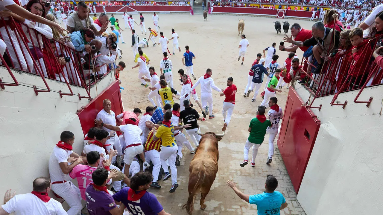 Quinto encierro de San Fermín 2025 con toros de la ganadería de Jandilla en el tramo del callejón y la entrada a la Plaza de Toros. IÑIGO ALZUGARAY