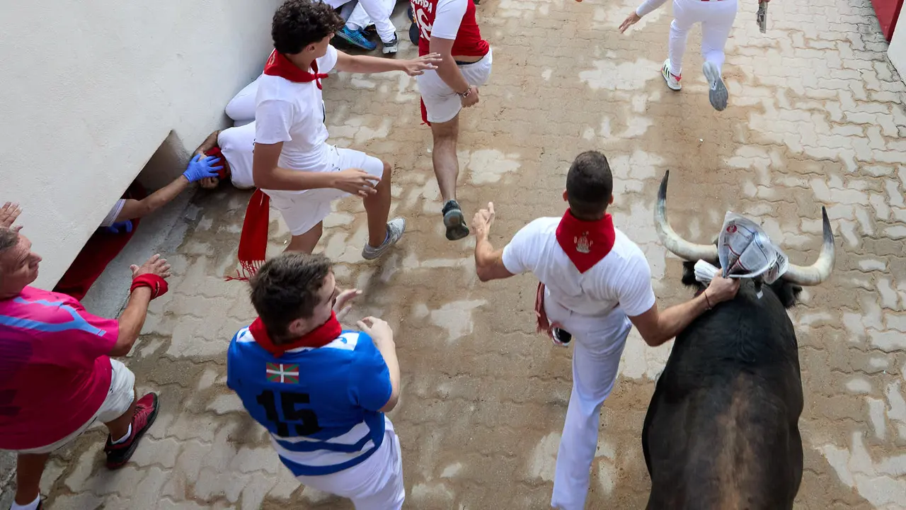 Quinto encierro de San Fermín 2025 con toros de la ganadería de Jandilla en el tramo del callejón y la entrada a la Plaza de Toros. IÑIGO ALZUGARAY