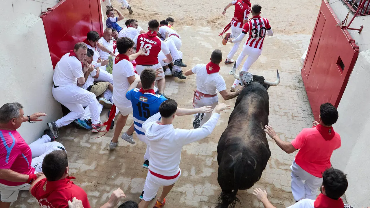 Quinto encierro de San Fermín 2025 con toros de la ganadería de Jandilla en el tramo del callejón y la entrada a la Plaza de Toros. IÑIGO ALZUGARAY