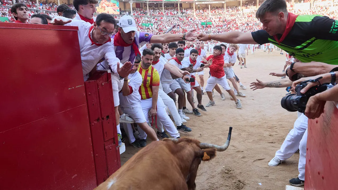 Quinto encierro de San Fermín 2025 con toros de la ganadería de Jandilla en el tramo del callejón y la entrada a la Plaza de Toros. IÑIGO ALZUGARAY