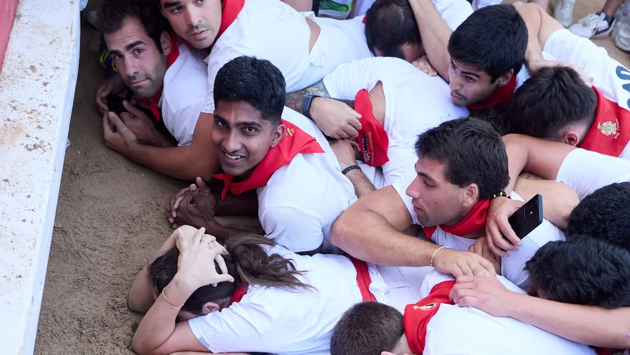 Quinto encierro de San Fermín 2025 con toros de la ganadería de Jandilla en el tramo del callejón y la entrada a la Plaza de Toros. IÑIGO ALZUGARAY