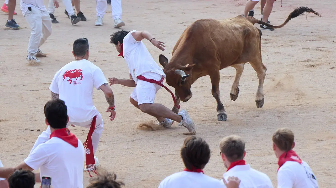 Quinto encierro de San Fermín 2025 con toros de la ganadería de Jandilla en el tramo del callejón y la entrada a la Plaza de Toros. IÑIGO ALZUGARAY