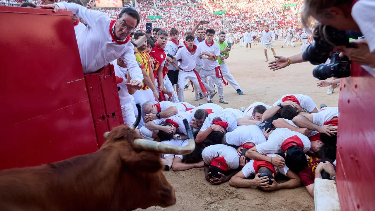 Quinto encierro de San Fermín 2025 con toros de la ganadería de Jandilla en el tramo del callejón y la entrada a la Plaza de Toros. IÑIGO ALZUGARAY
