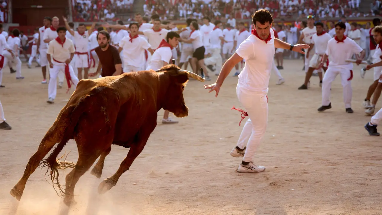Quinto encierro de San Fermín 2025 con toros de la ganadería de Jandilla en el tramo del callejón y la entrada a la Plaza de Toros. IÑIGO ALZUGARAY