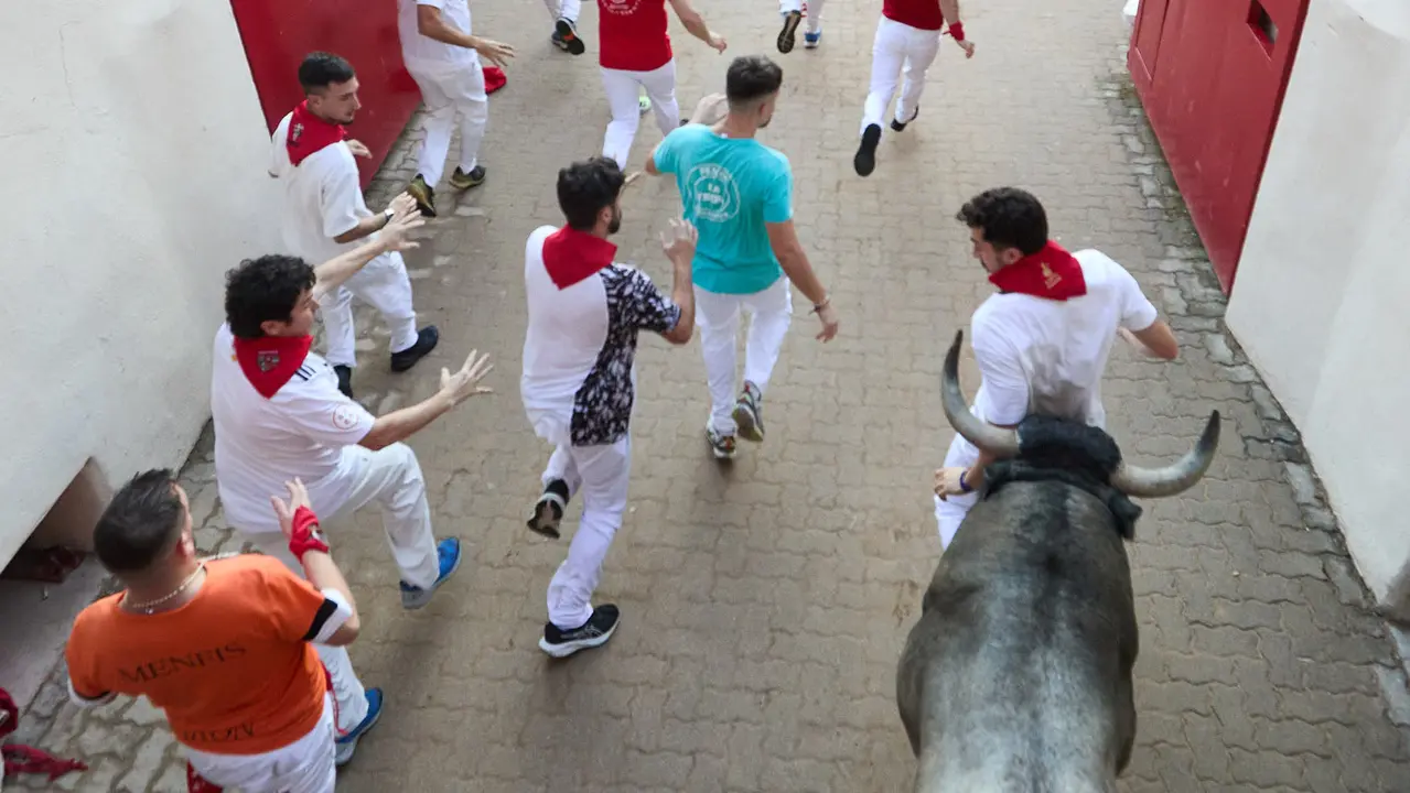 Sexto encierro de San Fermín 2025 con toros de la ganadería de José Escolar en el tramo del callejón y la entrada a la Plaza de Toros. IÑIGO ALZUGARAY