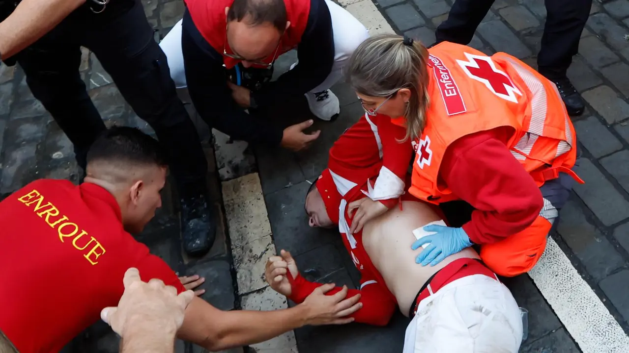 Los servicios de emergencia atienden a uno de los mozos tras el séptimo encierro de los Sanfermines 2025 este domingo en Pamplona. EFE Jesús Diges