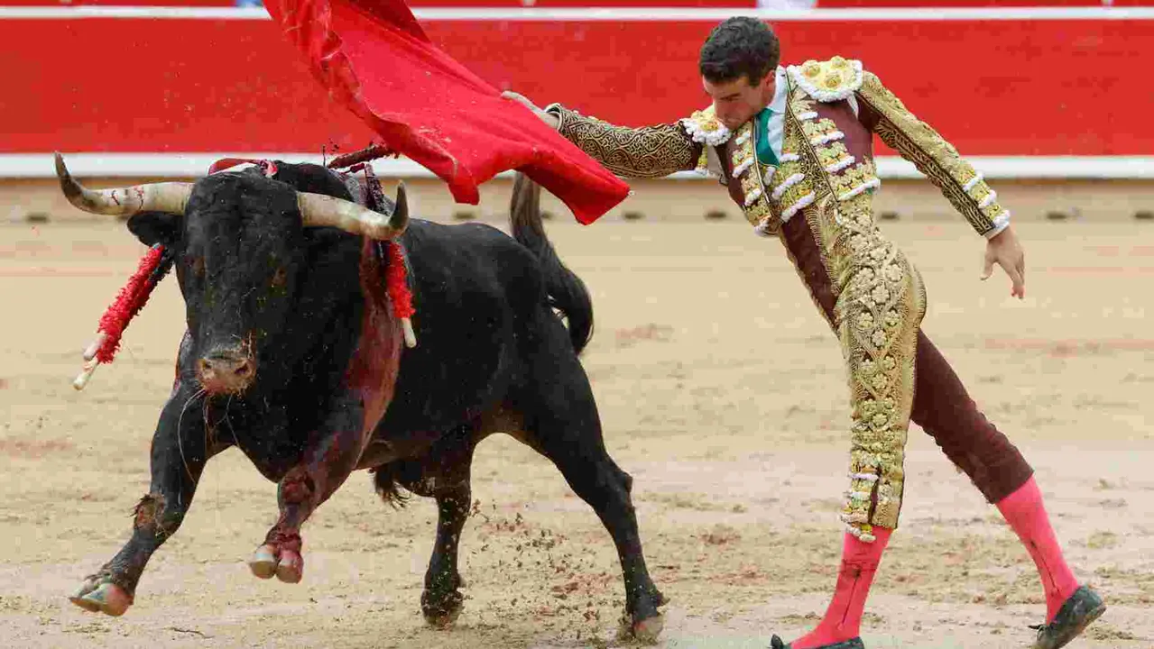 El torero Fernando Adrián durante la lidia a su primer toro de la tarde en la novena de abono de la Feria de Toro de los Sanfermines 2025 con toros de la ganadería gaditana La Palmosilla y en la que comparte cartel con los diestros Jiménez Fortes y Ginés Marín. EFE/Jesús Diges
