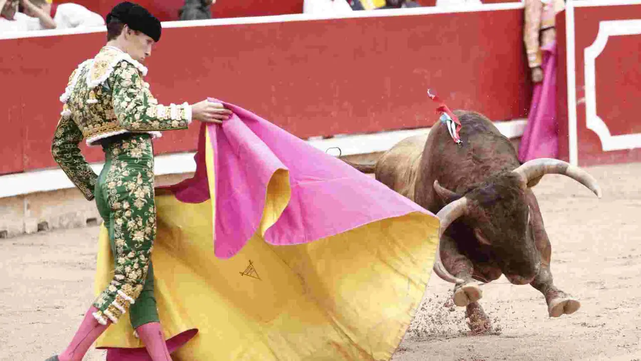 El torero Ginés Martín recibe con el capote a su primer toro de la tarde en la novena de abono de la Feria de Toro de los Sanfermines 2025 con toros de la ganadería gaditana La Palmosilla y en la que comparte cartel con los diestros Jiménez Fortes y Fernando Adrián. EFE/Jesús Diges