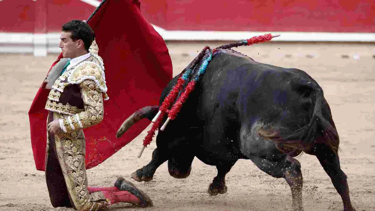El torero Fernando Adrián durante la lidia a su segundo toro de la tarde en la novena de abono de la Feria de Toro de los Sanfermines 2025 con toros de la ganadería gaditana La Palmosilla y en la que comparte cartel con los diestros Jiménez Fortes y Ginés Marín. EFE/Jesús Diges