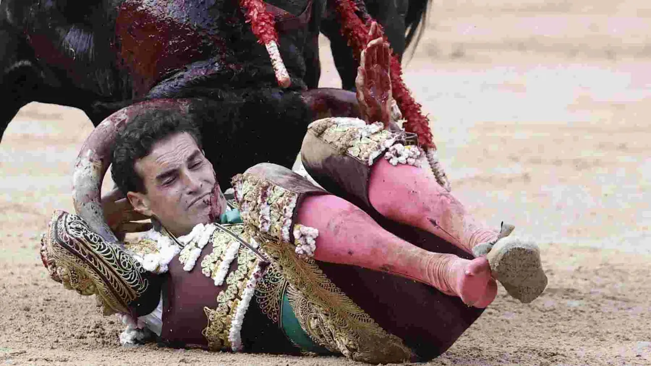 El torero Fernando Adrián sufre un revolcón durante la lidia a su segundo toro de la tarde en la novena de abono de la Feria de Toro de los Sanfermines 2025 con toros de la ganadería gaditana La Palmosilla y en la que comparte cartel con los diestros Jiménez Fortes y Ginés Marín. EFE/Jesús Diges