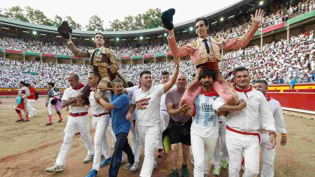 PAMPLONA, 13/07/2025.- Los diestros Fernando Adrián (i) y Jiménez Fortes salen a hombros a la finalización de la novena corrida de abono de la Feria de Toro de los Sanfermines 2025 que se ha celebrado hoy domingo en la plaza de toros de Pamplona. EFE/Jesús Diges
