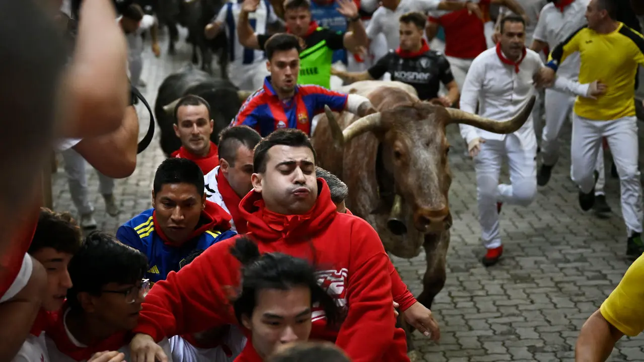 Octavo y último encierro de San Fermín 2025 con toros de Miura en la bajada al callejón. PABLO LASAOSA