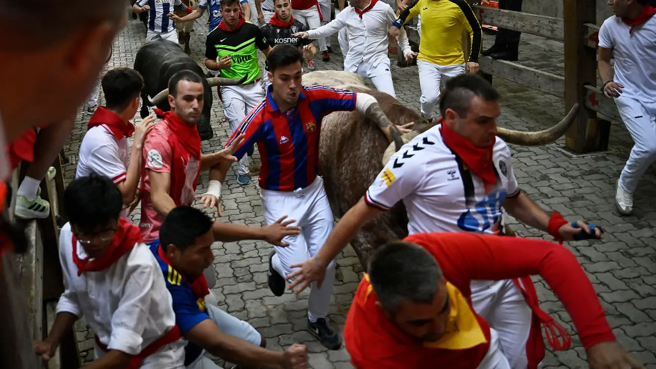 Octavo y último encierro de San Fermín 2025 con toros de Miura en la bajada al callejón. PABLO LASAOSA