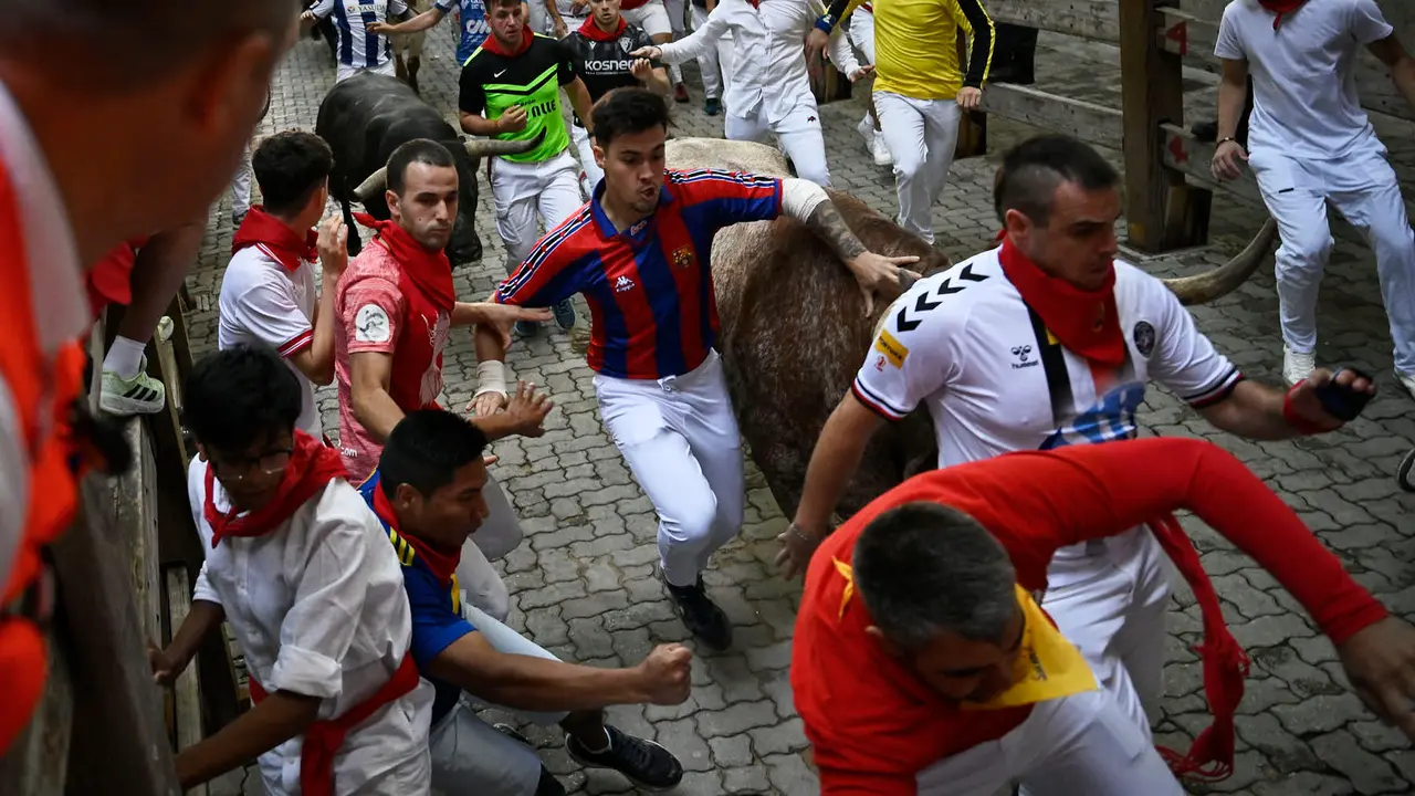 Octavo y último encierro de San Fermín 2025 con toros de Miura en la bajada al callejón. PABLO LASAOSA