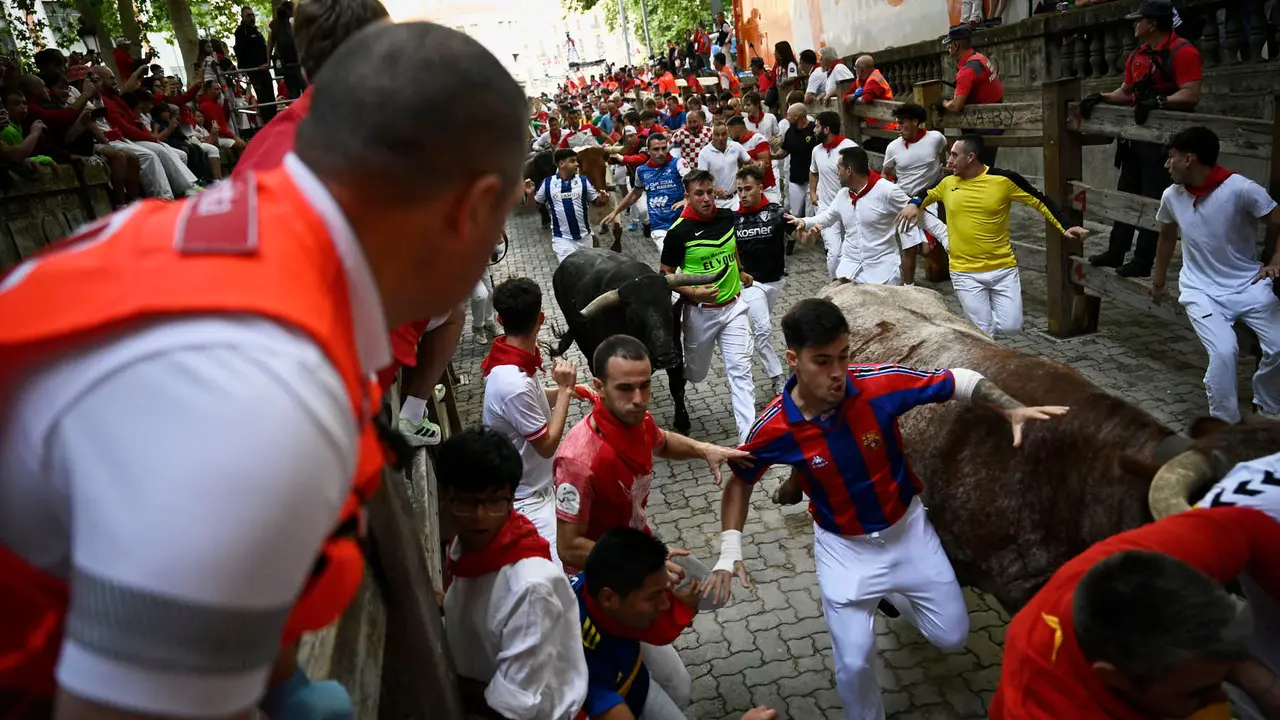 Octavo y último encierro de San Fermín 2025 con toros de Miura en la bajada al callejón. PABLO LASAOSA