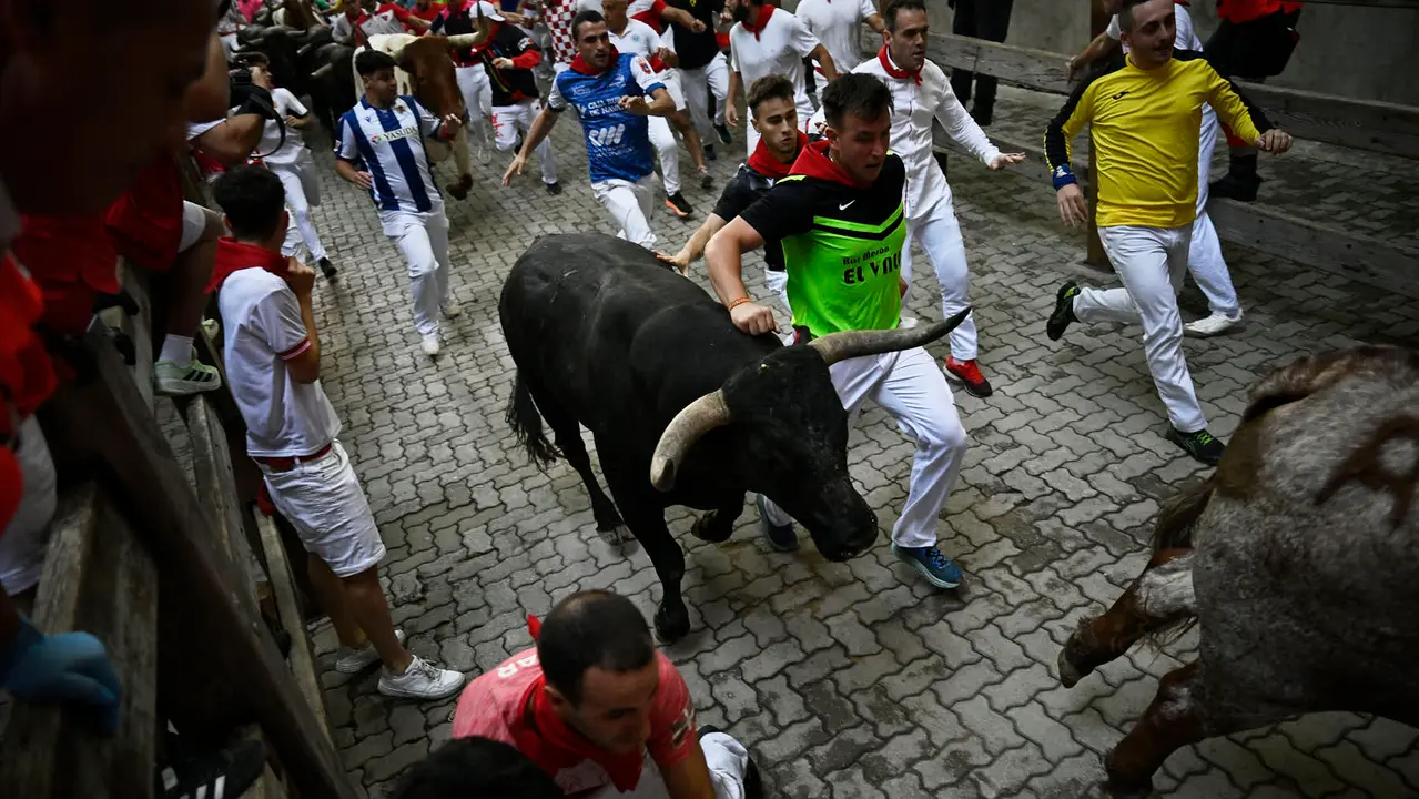 Octavo y último encierro de San Fermín 2025 con toros de Miura en la bajada al callejón. PABLO LASAOSA