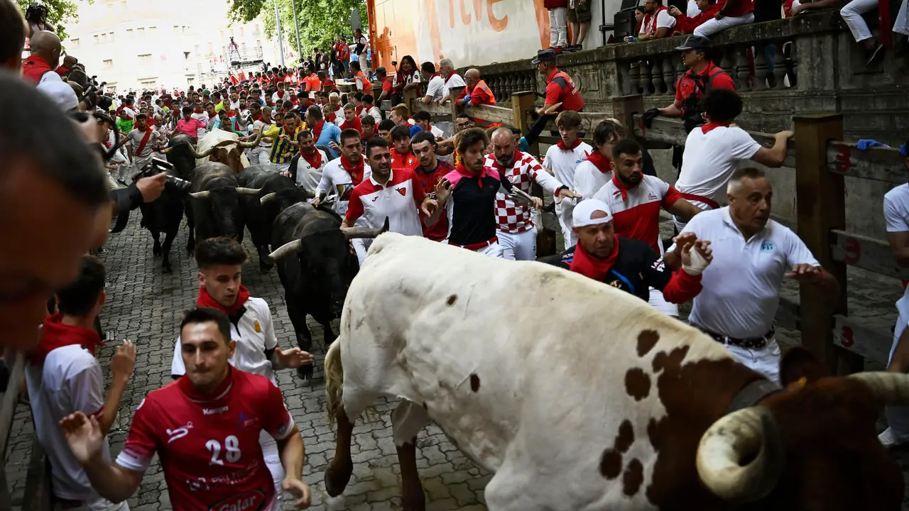 Octavo y último encierro de San Fermín 2025 con toros de Miura en la bajada al callejón. PABLO LASAOSA