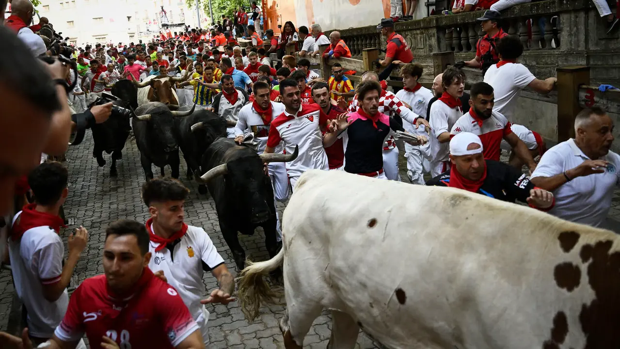 Octavo y último encierro de San Fermín 2025 con toros de Miura en la bajada al callejón. PABLO LASAOSA