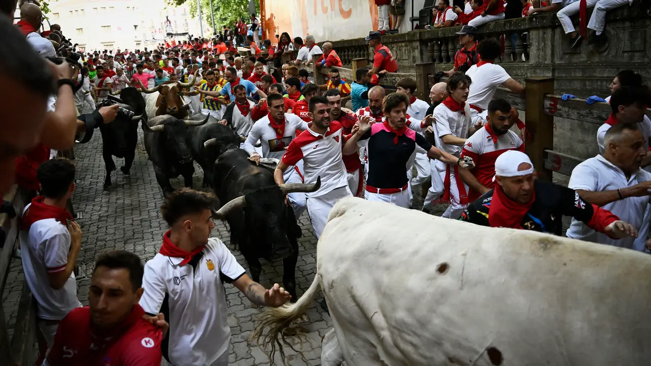 Octavo y último encierro de San Fermín 2025 con toros de Miura en la bajada al callejón. PABLO LASAOSA