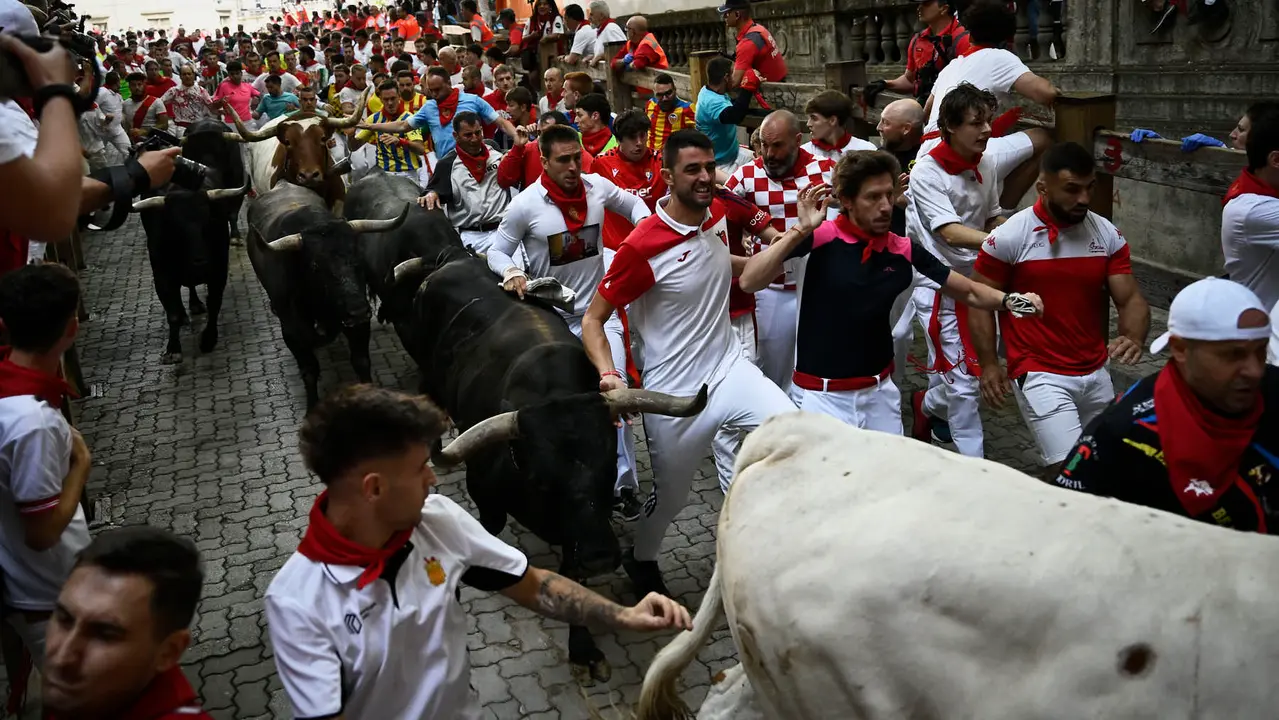 Octavo y último encierro de San Fermín 2025 con toros de Miura en la bajada al callejón. PABLO LASAOSA