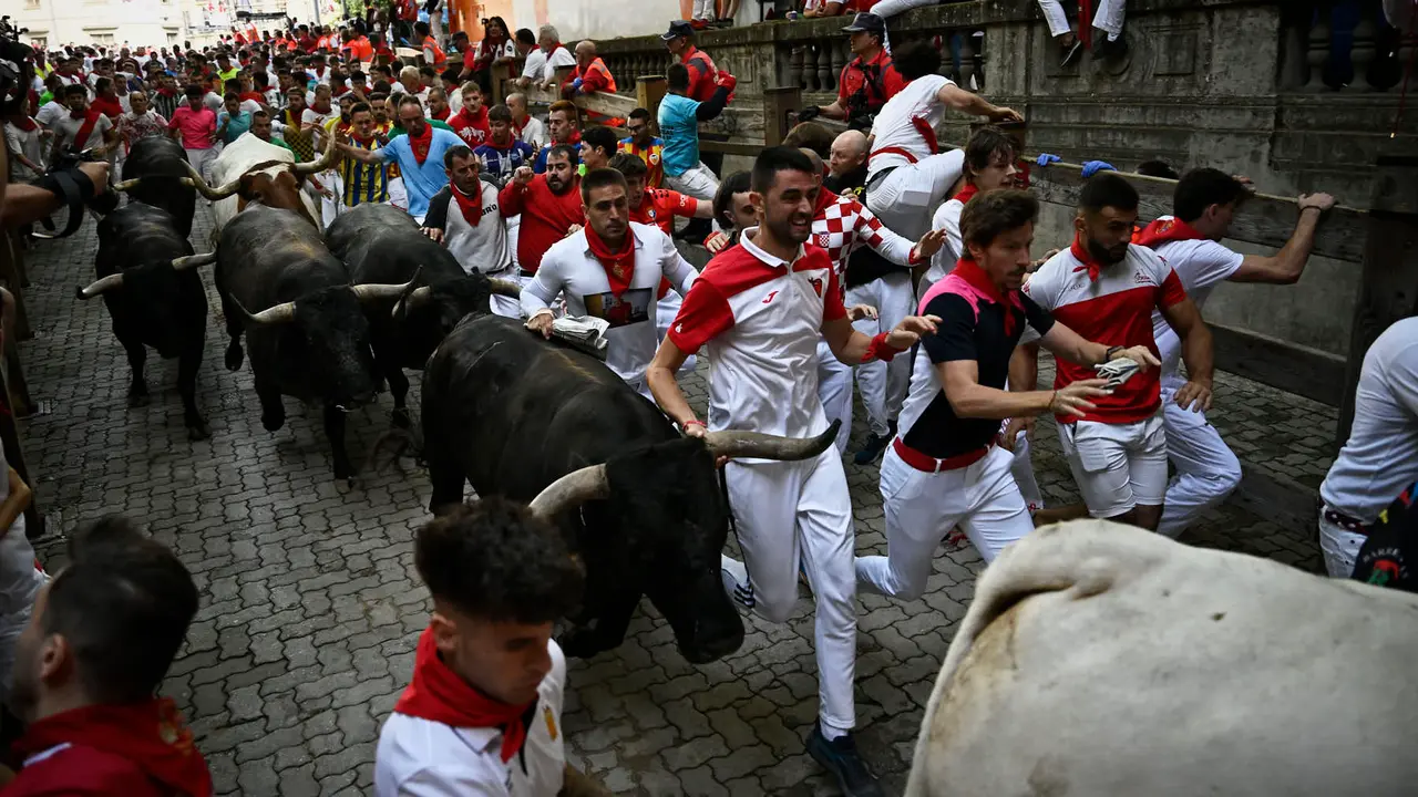 Octavo y último encierro de San Fermín 2025 con toros de Miura en la bajada al callejón. PABLO LASAOSA