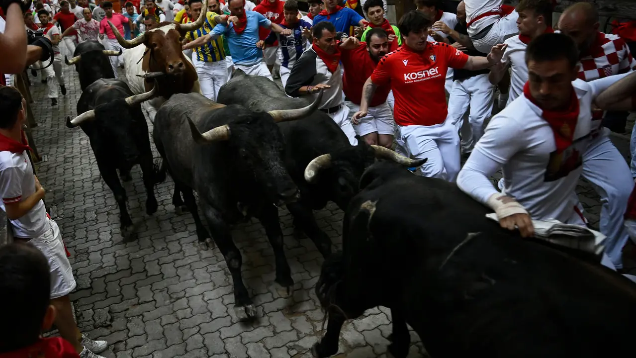 Octavo y último encierro de San Fermín 2025 con toros de Miura en la bajada al callejón. PABLO LASAOSA