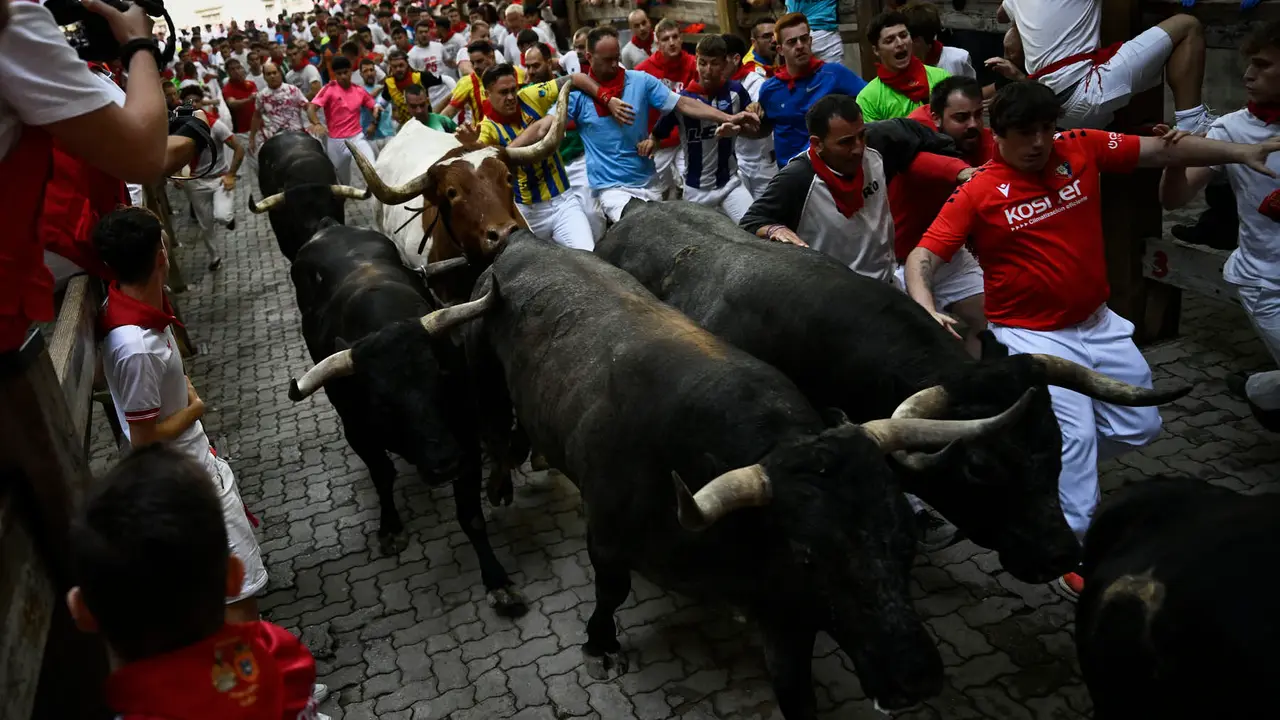 Octavo y último encierro de San Fermín 2025 con toros de Miura en la bajada al callejón. PABLO LASAOSA