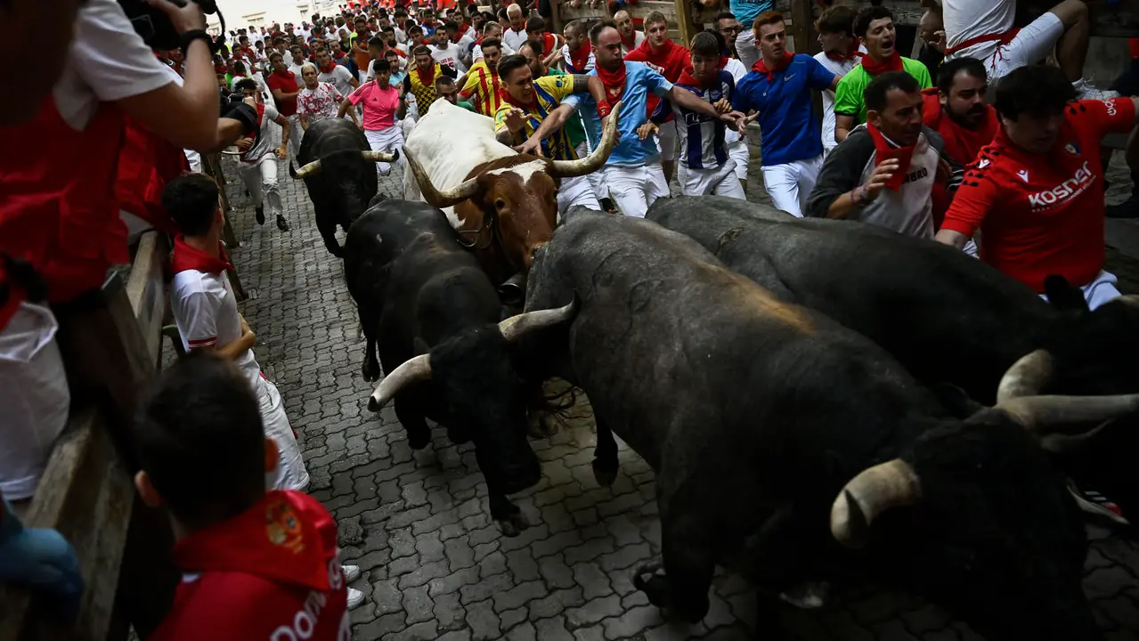 Octavo y último encierro de San Fermín 2025 con toros de Miura en la bajada al callejón. PABLO LASAOSA