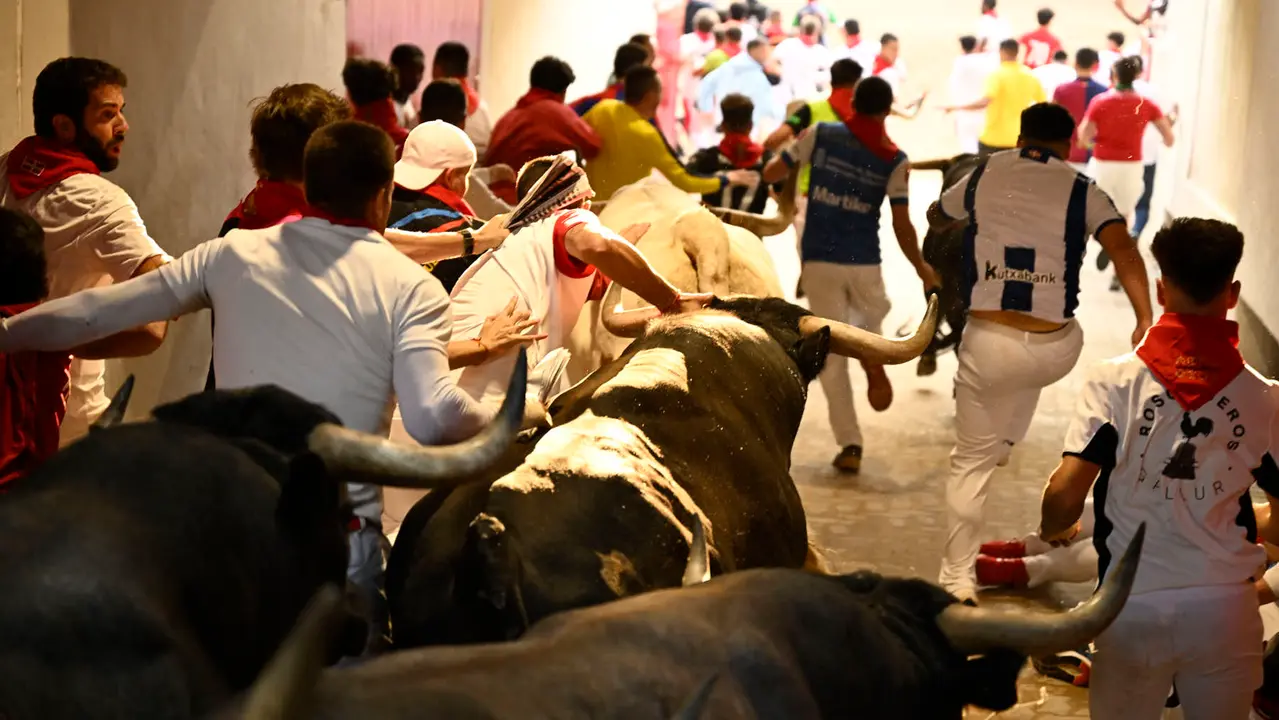 Octavo y último encierro de San Fermín 2025 con toros de Miura en la bajada al callejón. PABLO LASAOSA