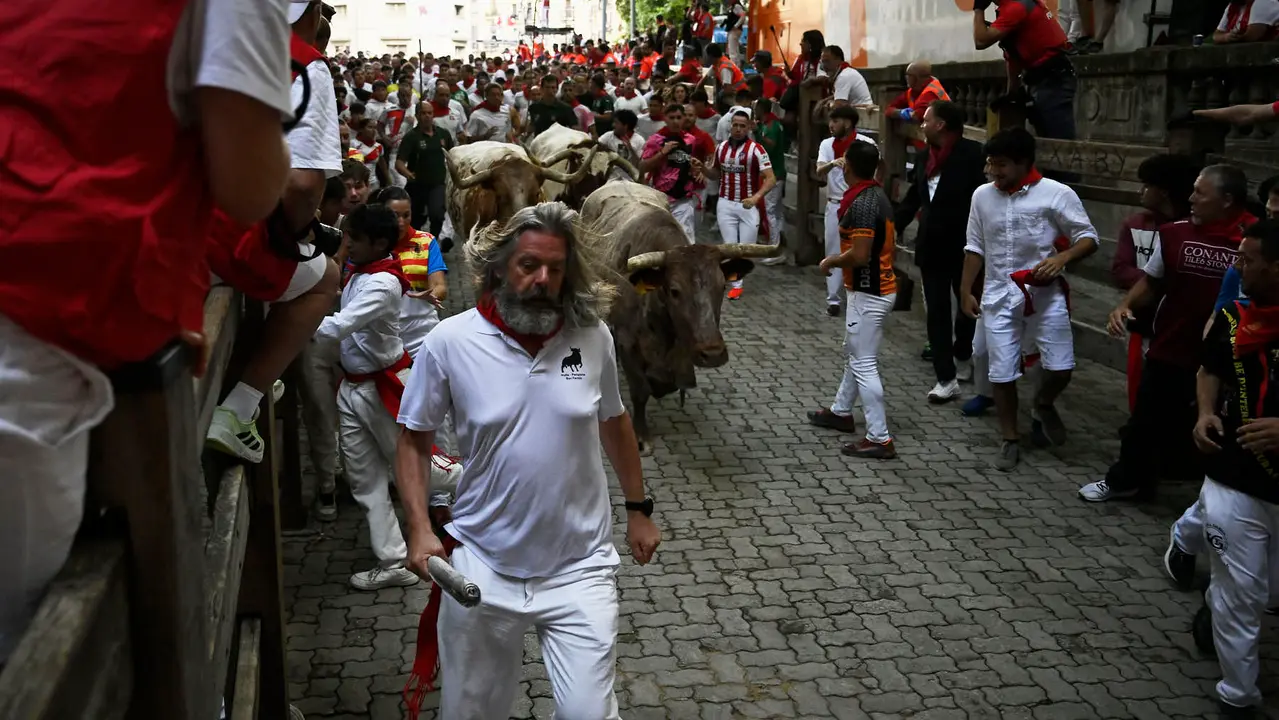 Octavo y último encierro de San Fermín 2025 con toros de Miura en la bajada al callejón. PABLO LASAOSA