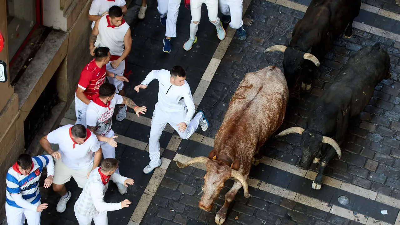 Octavo y último encierro de San Fermín 2025 con toros de la ganadería de Miura en el tramo de Mercaderes. IÑIGO ALZUGARAY