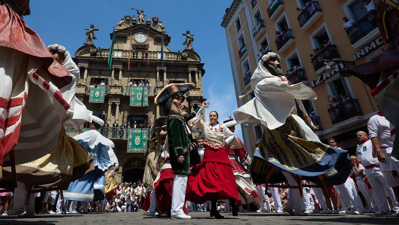 La Comparsa de Gigantes y Cabezudos acompañada del grupo de danzas Duguna Iruñeko Dantzariak bailan en honor a la ciudad antes de su despedida en la plaza del Ayuntamiento de Pamplona en el último día de las fiestas de San Fermín 2025. IÑIGO ALZUGARAY