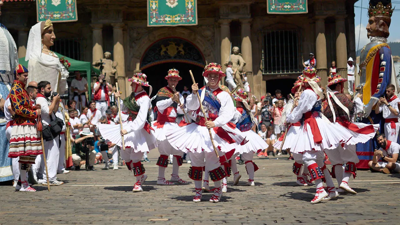 La Comparsa de Gigantes y Cabezudos acompañada del grupo de danzas Duguna Iruñeko Dantzariak bailan en honor a la ciudad antes de su despedida en la plaza del Ayuntamiento de Pamplona en el último día de las fiestas de San Fermín 2025. IÑIGO ALZUGARAY