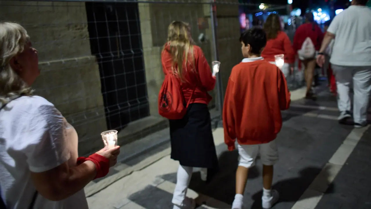 Cientos de personas depositan sus velas y pañuelos frente a la Iglesia de San Lorenzo momentos después del Pobre de mí con el que finalizan los nueve días de las Fiestas de San Fermín 2025. IÑIGO ALZUGARAY