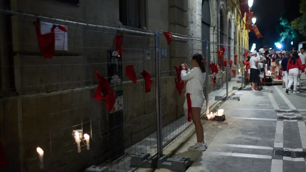 Cientos de personas depositan sus velas y pañuelos frente a la Iglesia de San Lorenzo momentos después del Pobre de mí con el que finalizan los nueve días de las Fiestas de San Fermín 2025. IÑIGO ALZUGARAY