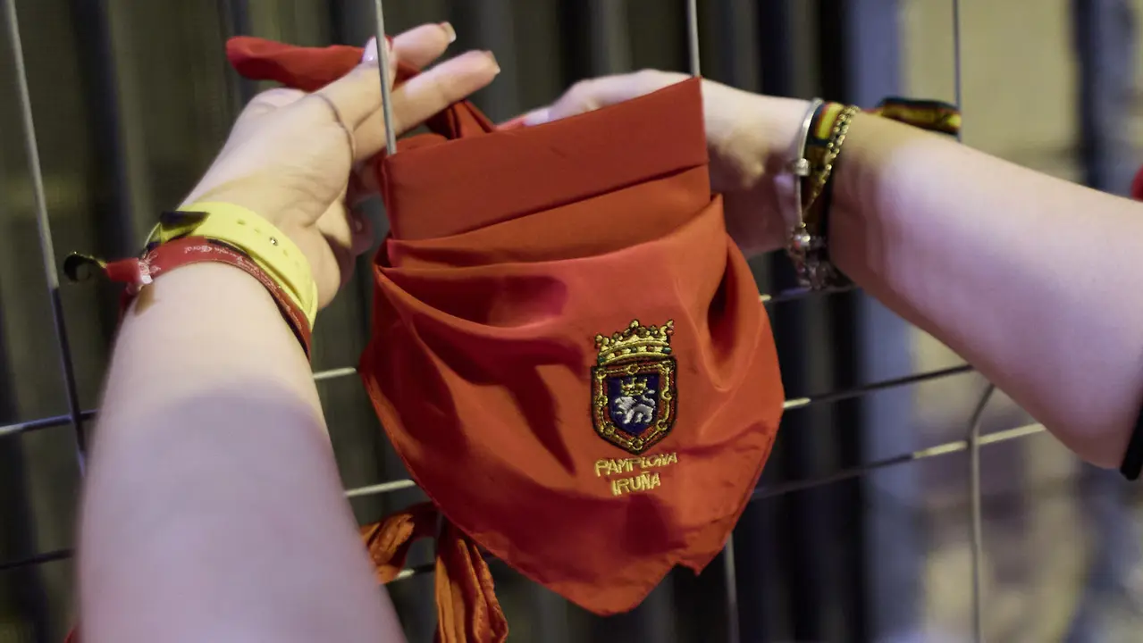 Cientos de personas depositan sus velas y pañuelos frente a la Iglesia de San Lorenzo momentos después del Pobre de mí con el que finalizan los nueve días de las Fiestas de San Fermín 2025. IÑIGO ALZUGARAY
