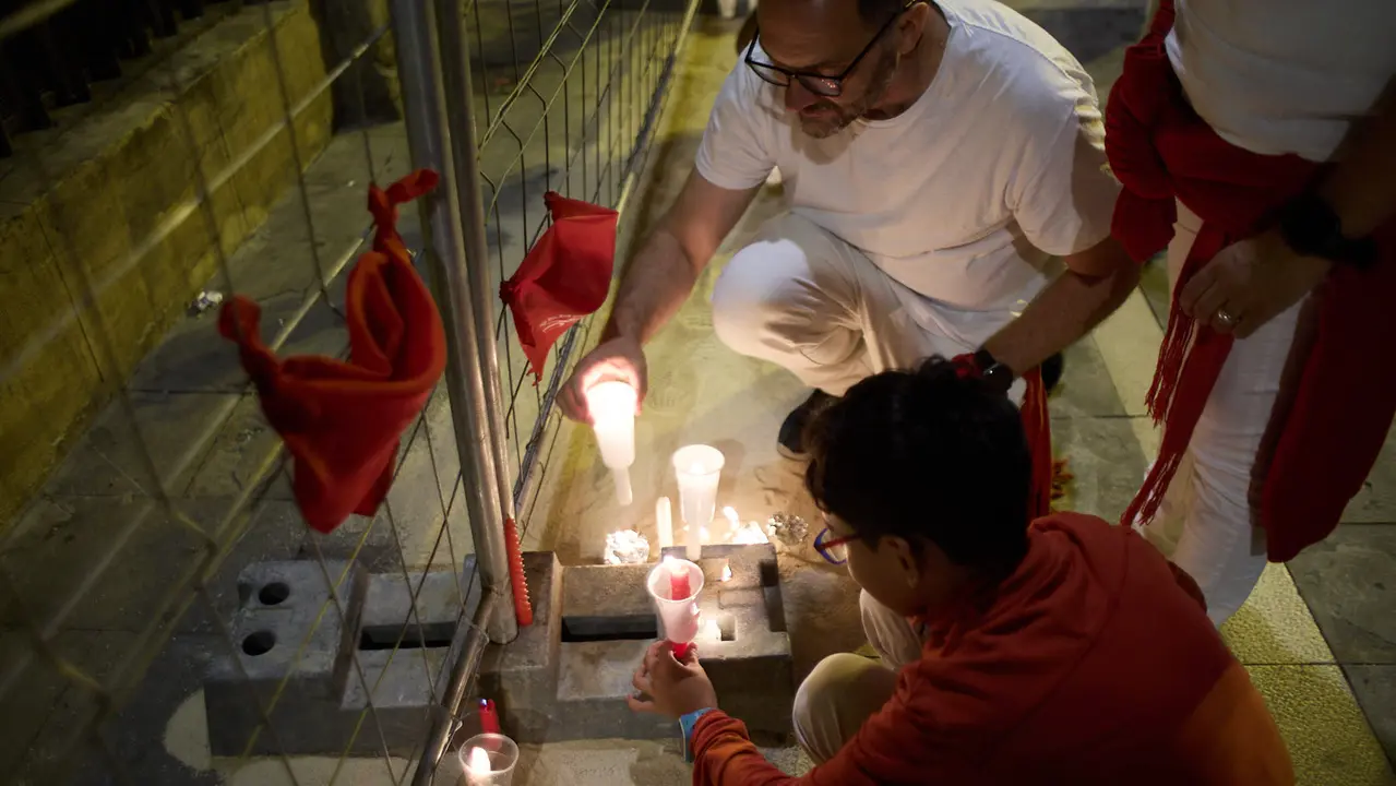 Cientos de personas depositan sus velas y pañuelos frente a la Iglesia de San Lorenzo momentos después del Pobre de mí con el que finalizan los nueve días de las Fiestas de San Fermín 2025. IÑIGO ALZUGARAY