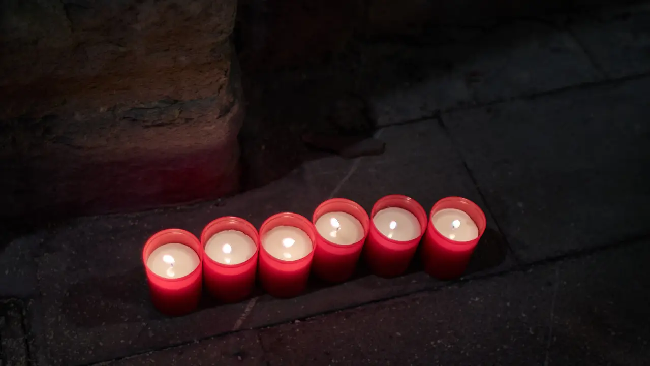Cientos de personas depositan sus velas y pañuelos frente a la Iglesia de San Lorenzo momentos después del Pobre de mí con el que finalizan los nueve días de las Fiestas de San Fermín 2025. IÑIGO ALZUGARAY