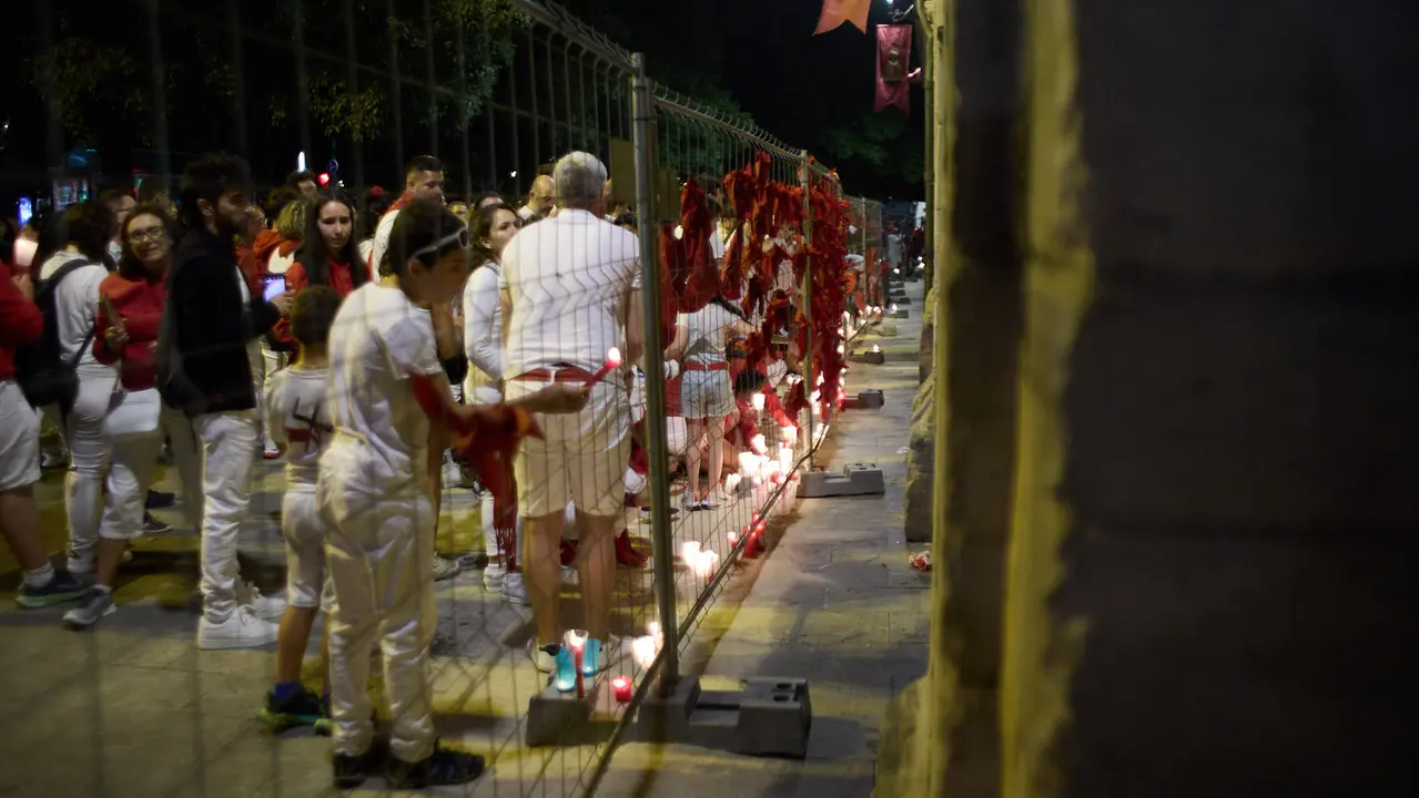 Cientos de personas depositan sus velas y pañuelos frente a la Iglesia de San Lorenzo momentos después del Pobre de mí con el que finalizan los nueve días de las Fiestas de San Fermín 2025. IÑIGO ALZUGARAY