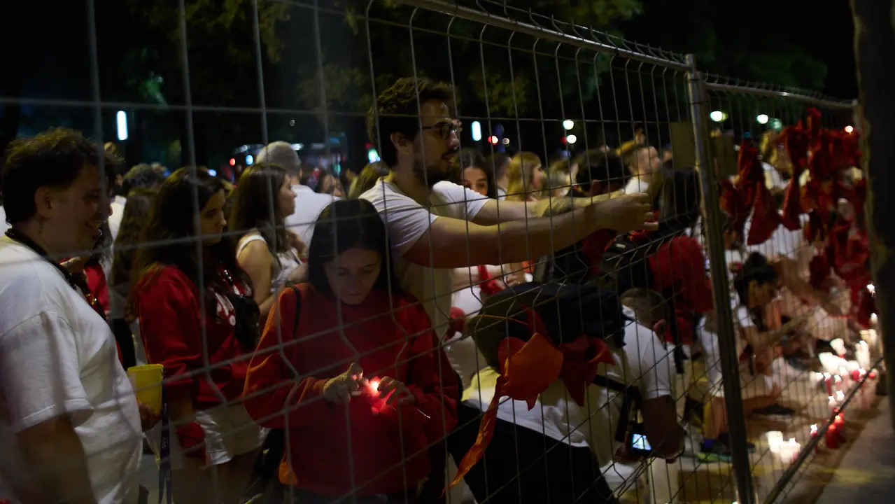 Cientos de personas depositan sus velas y pañuelos frente a la Iglesia de San Lorenzo momentos después del Pobre de mí con el que finalizan los nueve días de las Fiestas de San Fermín 2025. IÑIGO ALZUGARAY