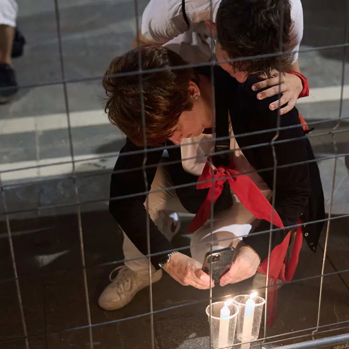 Cientos de personas depositan sus velas y pañuelos frente a la Iglesia de San Lorenzo momentos después del Pobre de mí con el que finalizan los nueve días de las Fiestas de San Fermín 2025. IÑIGO ALZUGARAY