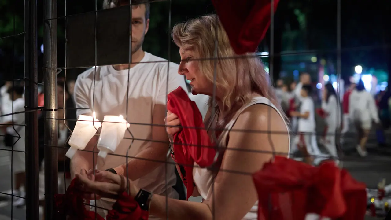 Cientos de personas depositan sus velas y pañuelos frente a la Iglesia de San Lorenzo momentos después del Pobre de mí con el que finalizan los nueve días de las Fiestas de San Fermín 2025. IÑIGO ALZUGARAY